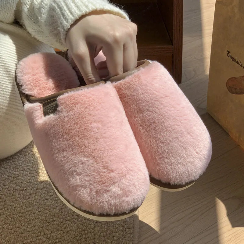 Solid colour PVC plush winter house slippers on a wooden floor.