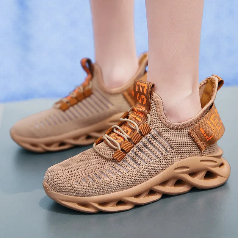 Child wearing trendy black coconut sneakers with Velcro strap and fabric upper.