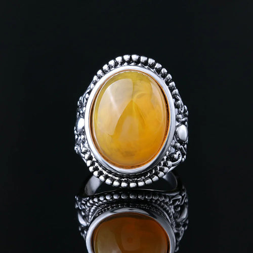 Geometric retro alloy ring in antique silver amber colour on a plain background.