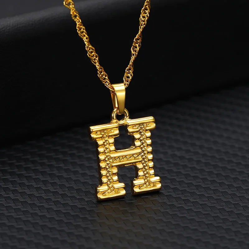 Gold-plated alloy initial pendant necklace with 42cm chain on white background