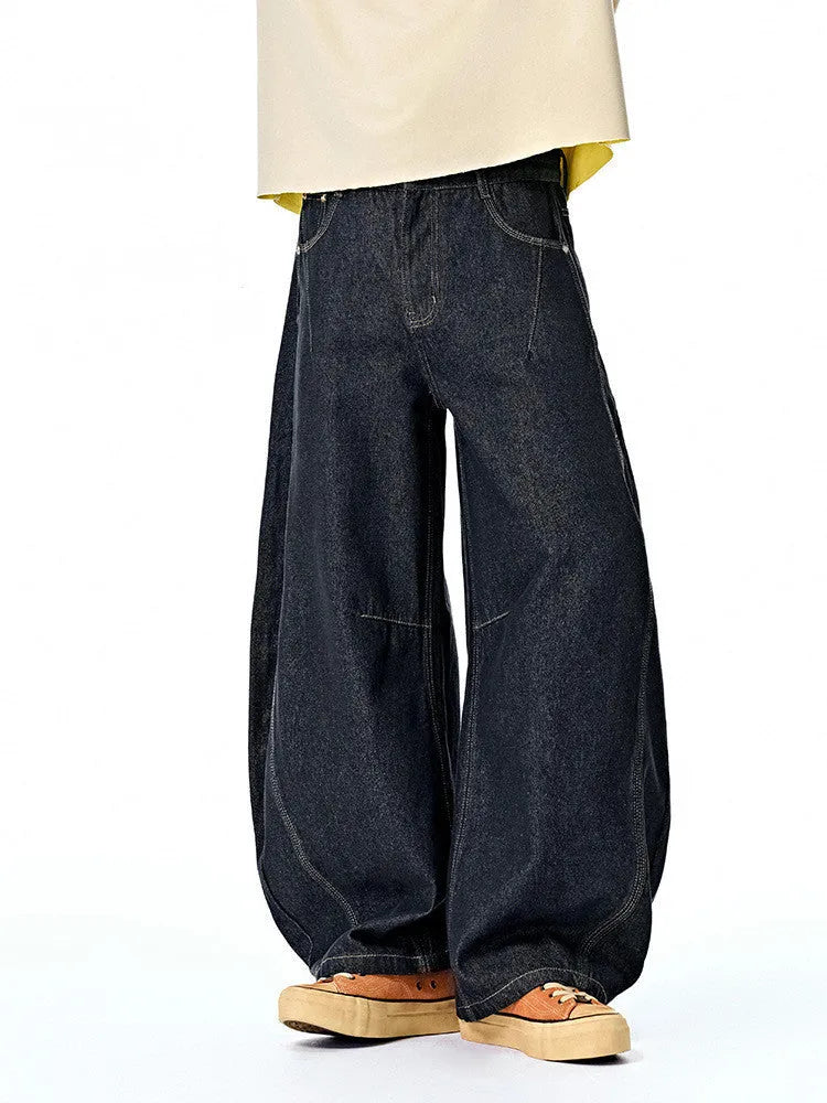 Men's original cow colour wide leg denim trousers laid flat showing mid-waist and relaxed leg cut