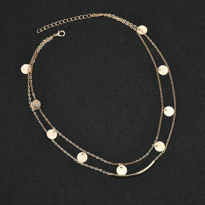 Gold alloy geometric pendant necklace with multi-sequin finish on display