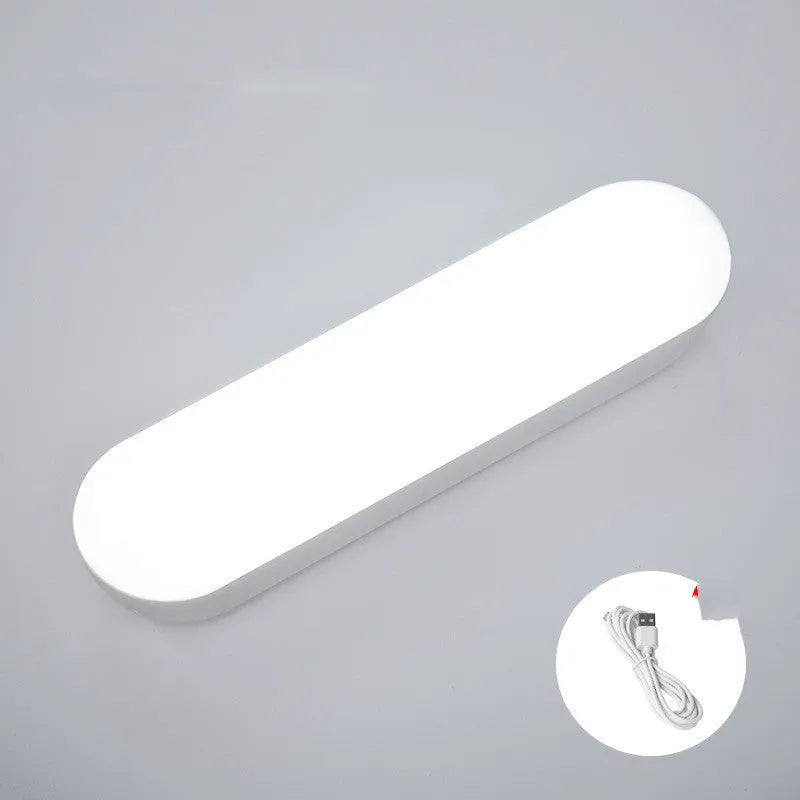 Fully automatic unplugged bedside night light for dormitory with magnetic base, USB rechargeable, showing yellow light mode on a dark bedside table