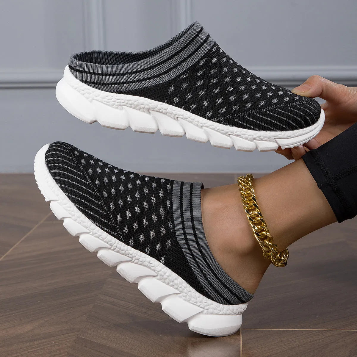 Women's black flyknit semi-slipper sock shoes with striped pattern and hollowed-out sewing lines on a lightweight sole.