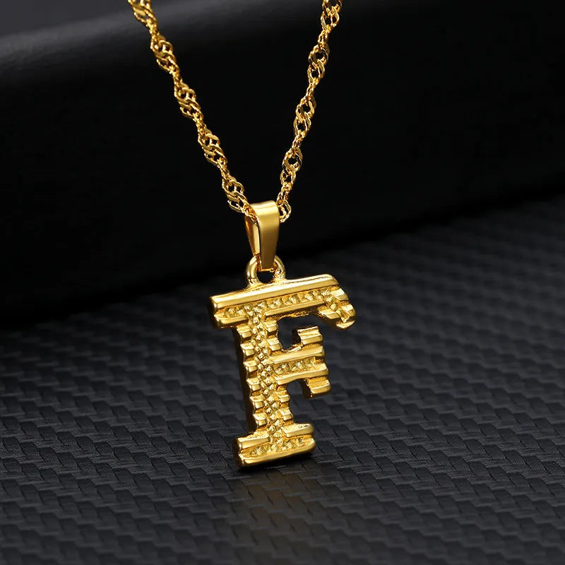 Gold-plated alloy initial pendant necklace with 42cm chain on white background