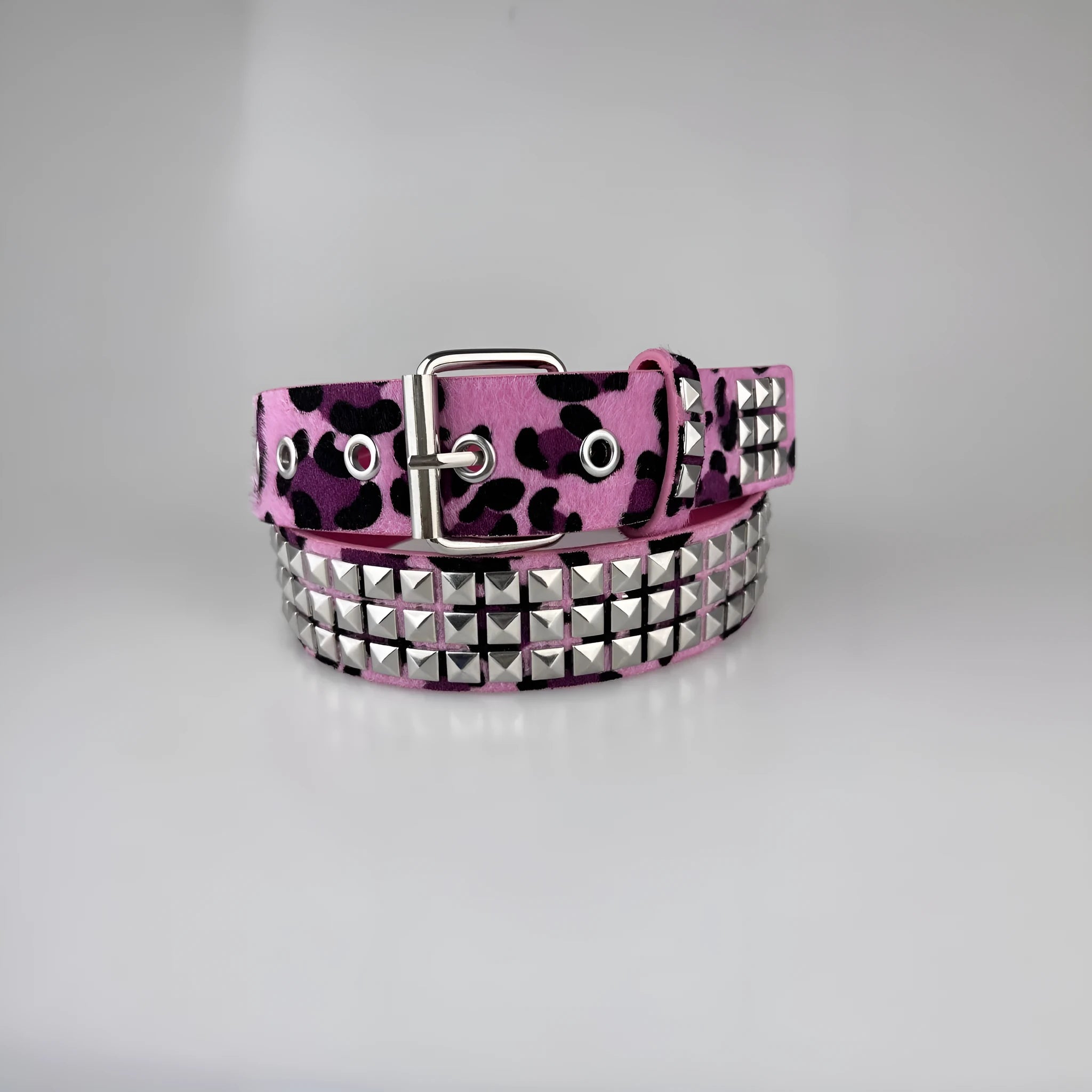 Women's punk fashion belt with metal pyramid studs in leopard print pattern, showing alloy buckle and PU leather strap.