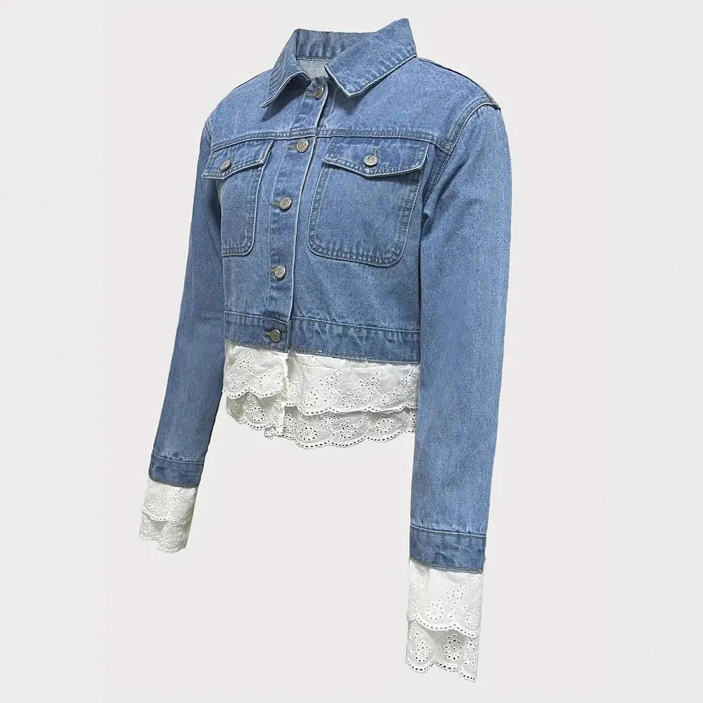 Blue women's denim jacket with decorative lace stitching on the front and sleeves.