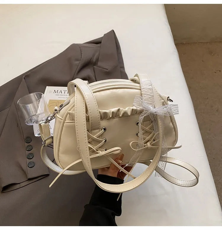Ladies shoulder handbag with bandage bow design in PU leather showing phone pocket compartment