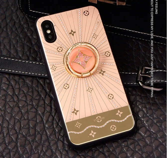 Luxury diamond and gold ring holder stand holding an iPhone for hands-free viewing.