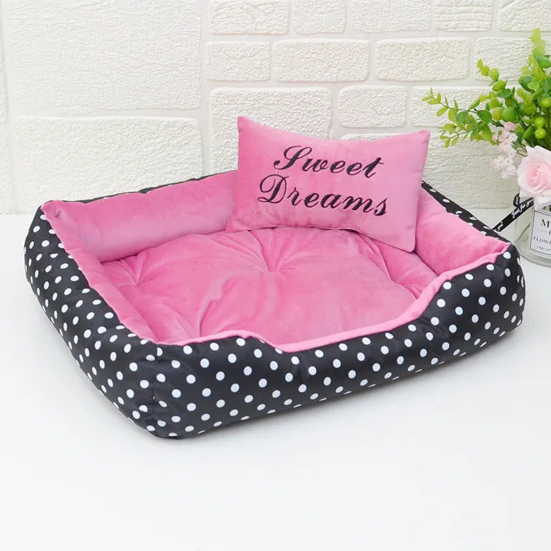 Polka dot print dog bed with matching embroidered cushion in grey, shown in a home setting.