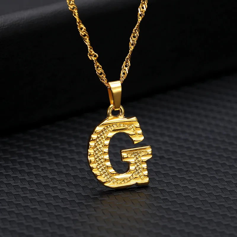 Gold-plated alloy initial pendant necklace with 42cm chain on white background