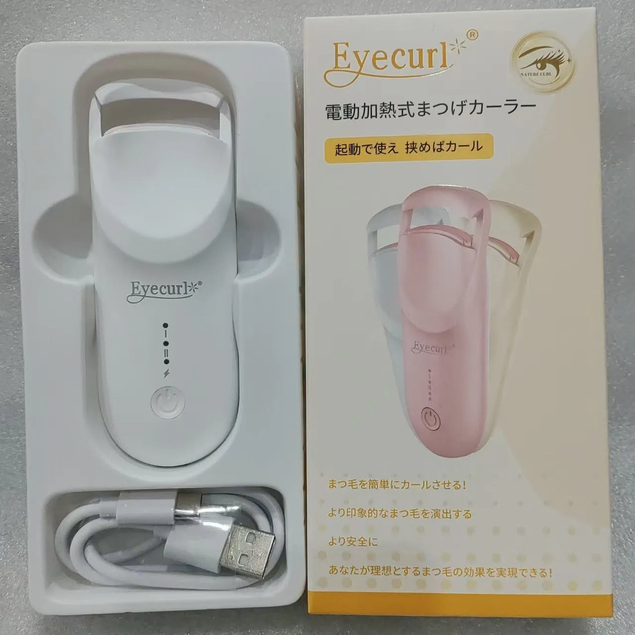 Electric heating eyelash curler in plastic housing with USB cable on a vanity