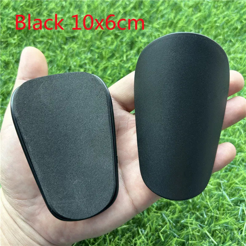 Extra small mini football shin guards in black and white colours measuring 8cm by 5cm