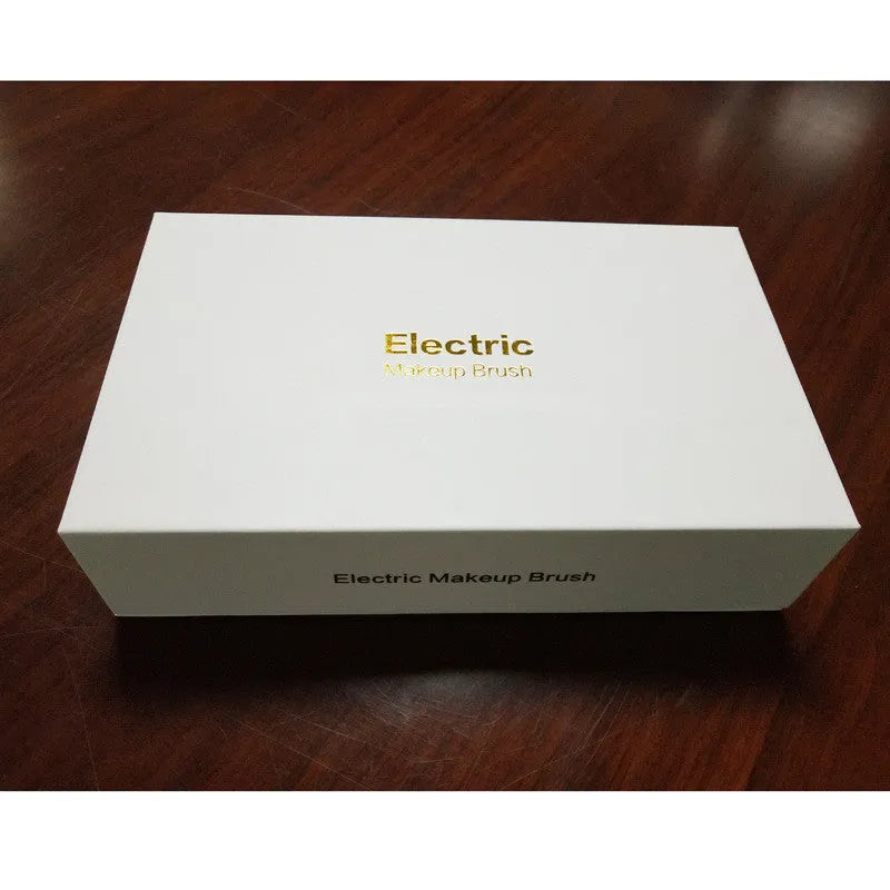 Electric makeup brush with white body, fibre wool bristles, and two rounded brush heads including foundation and blush applicators