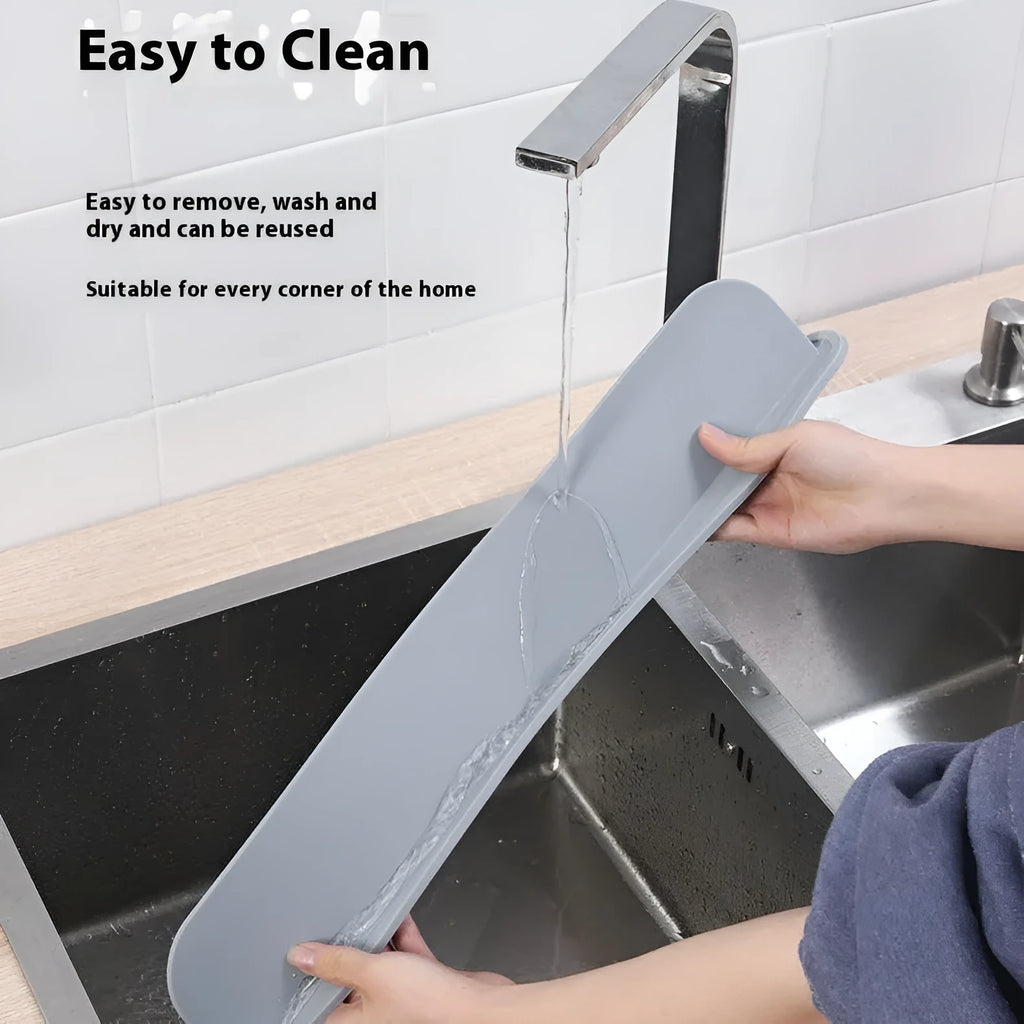 Grey silicone sink splash guard water blocking plate placed on a kitchen sink edge
