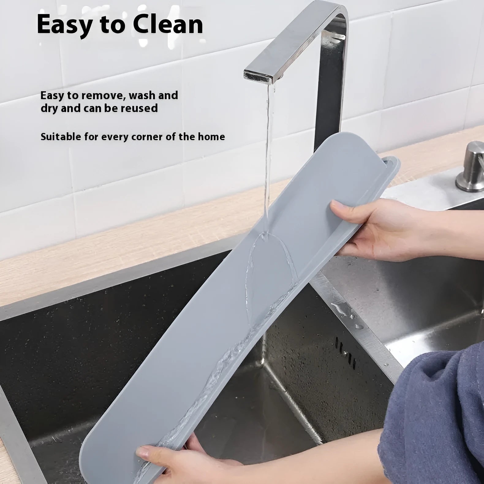 Grey silicone sink splash guard water blocking plate placed on a kitchen sink edge