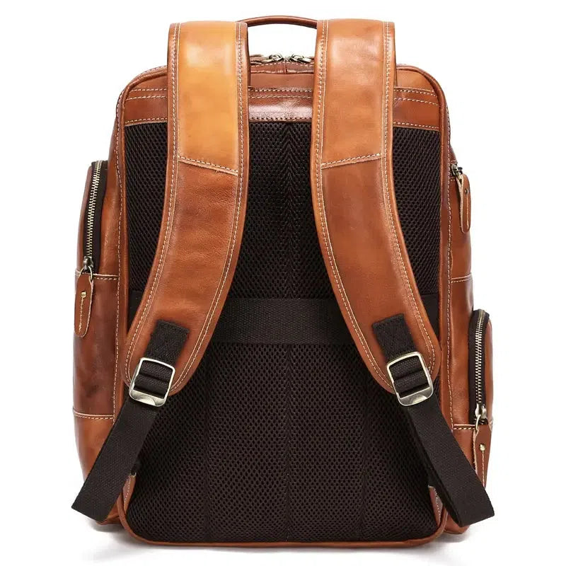 Bronze real leather backpack with structured form, zipper closure, top handle, and adjustable shoulder straps.