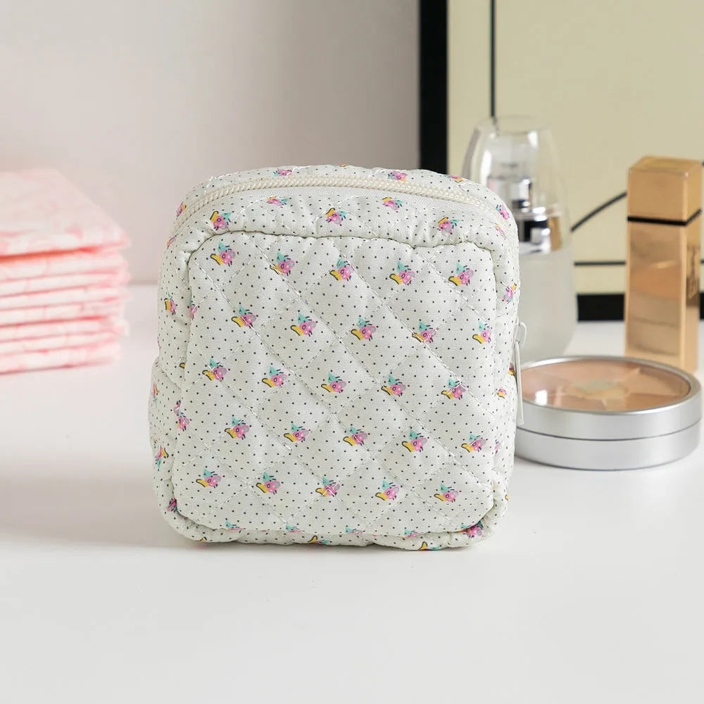 Yellow floral polyester key storage bag with sewing thread detail next to red small flower design variant.