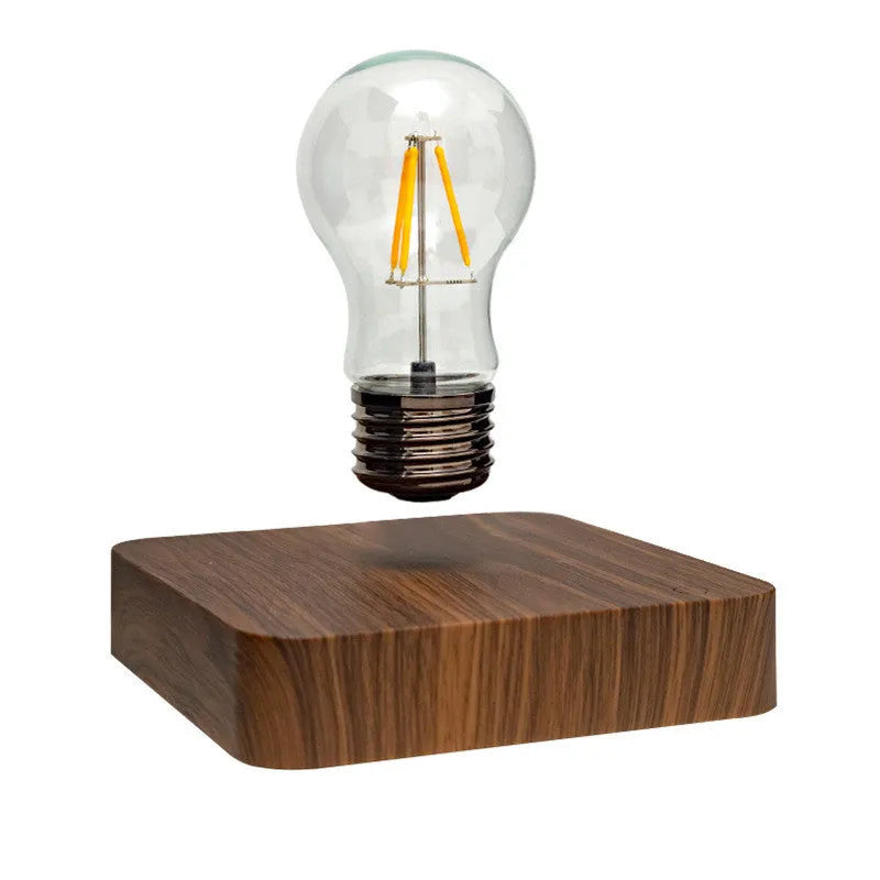 Creative minimal self-rotating maglev bulb with ABS base and warm yellow light on a desk
