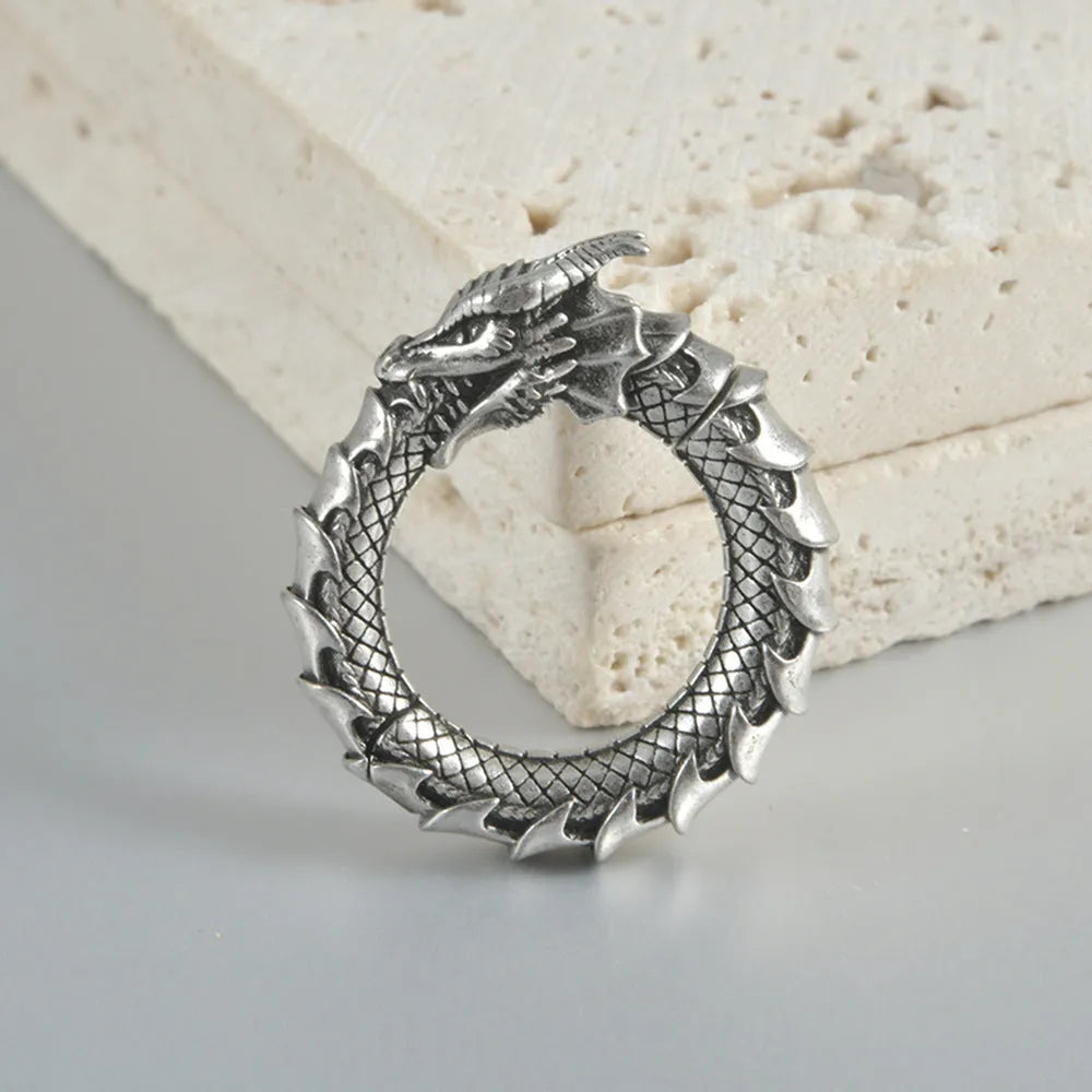 A pair of large antique silver alloy earrings featuring a hollow out geometric dragon design.