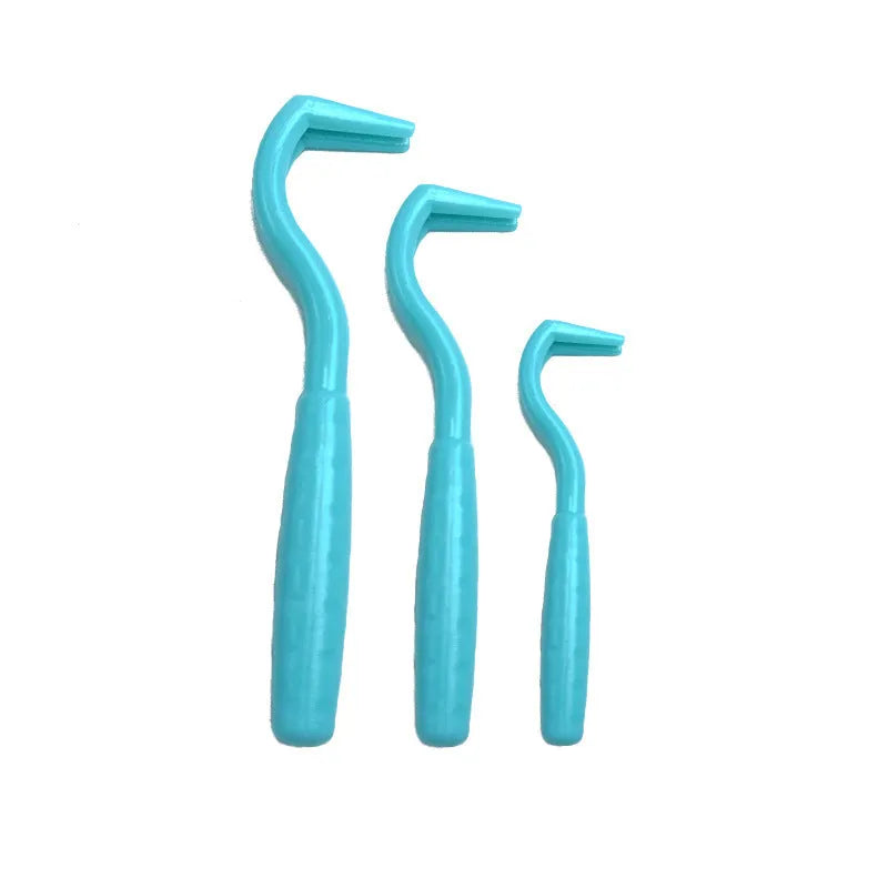 Three plastic tick removal hooks for dogs in assorted colours on a white background.