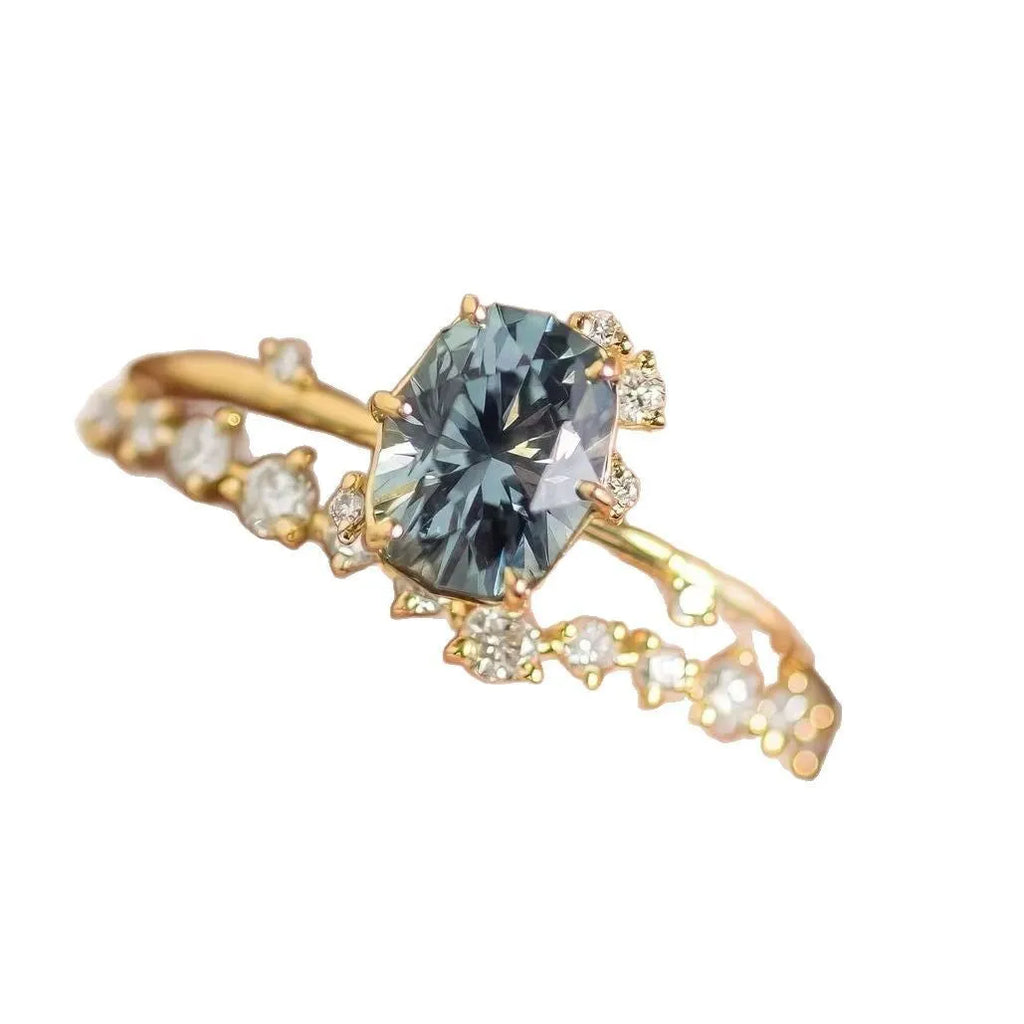 Gold plated women's ring with green zircon stone in floral design on a model's finger.