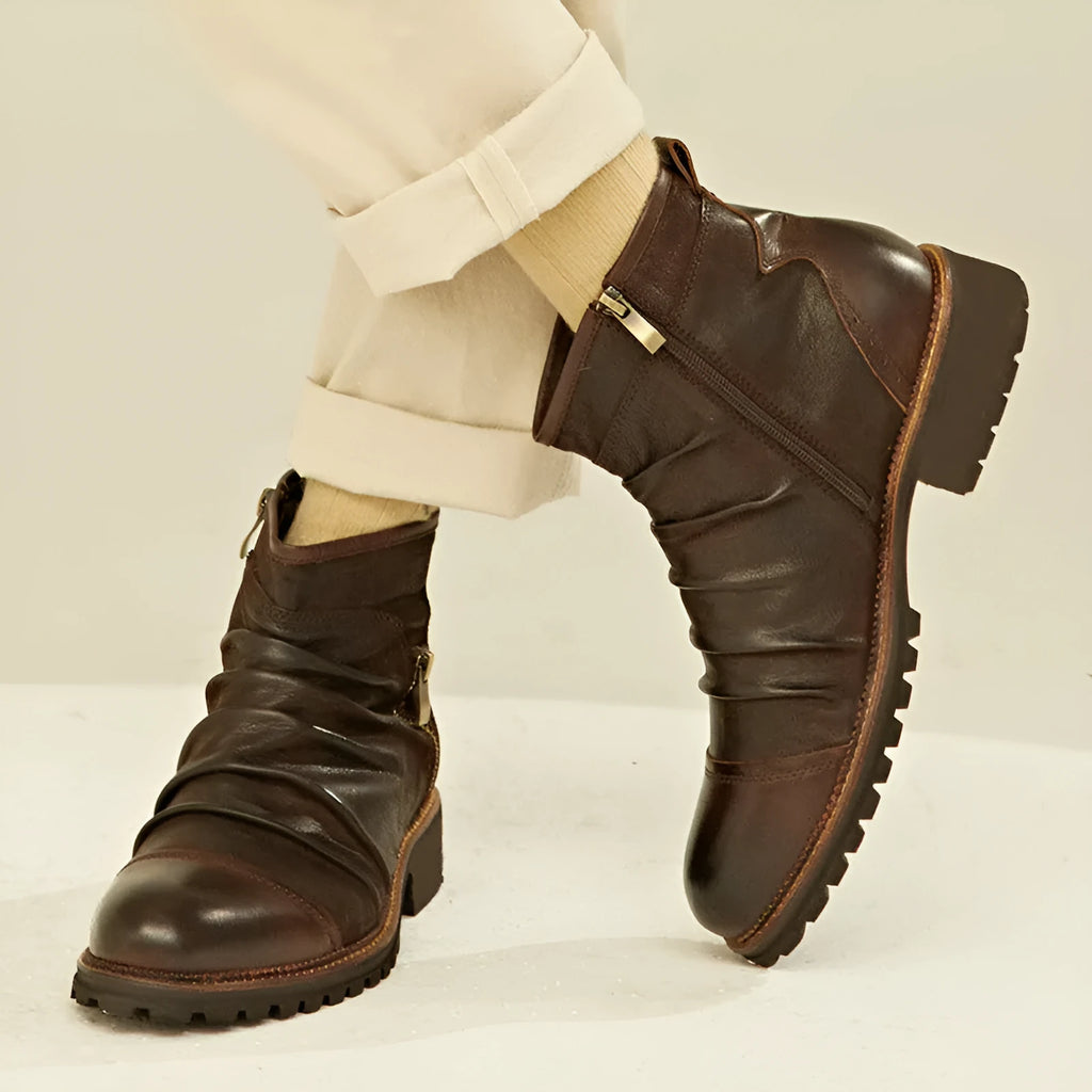 Men's black side-zip cowboy boots with a round toe and horseshoe heel on a wooden floor.