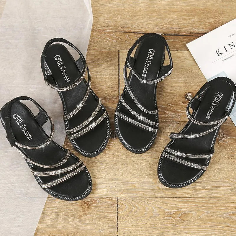 Women's silver flat sandals with rhinestone detail, round toe, and elastic band strap.