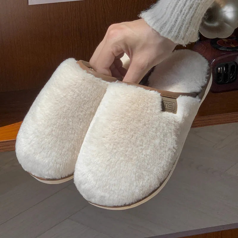Solid colour PVC plush winter house slippers on a wooden floor.