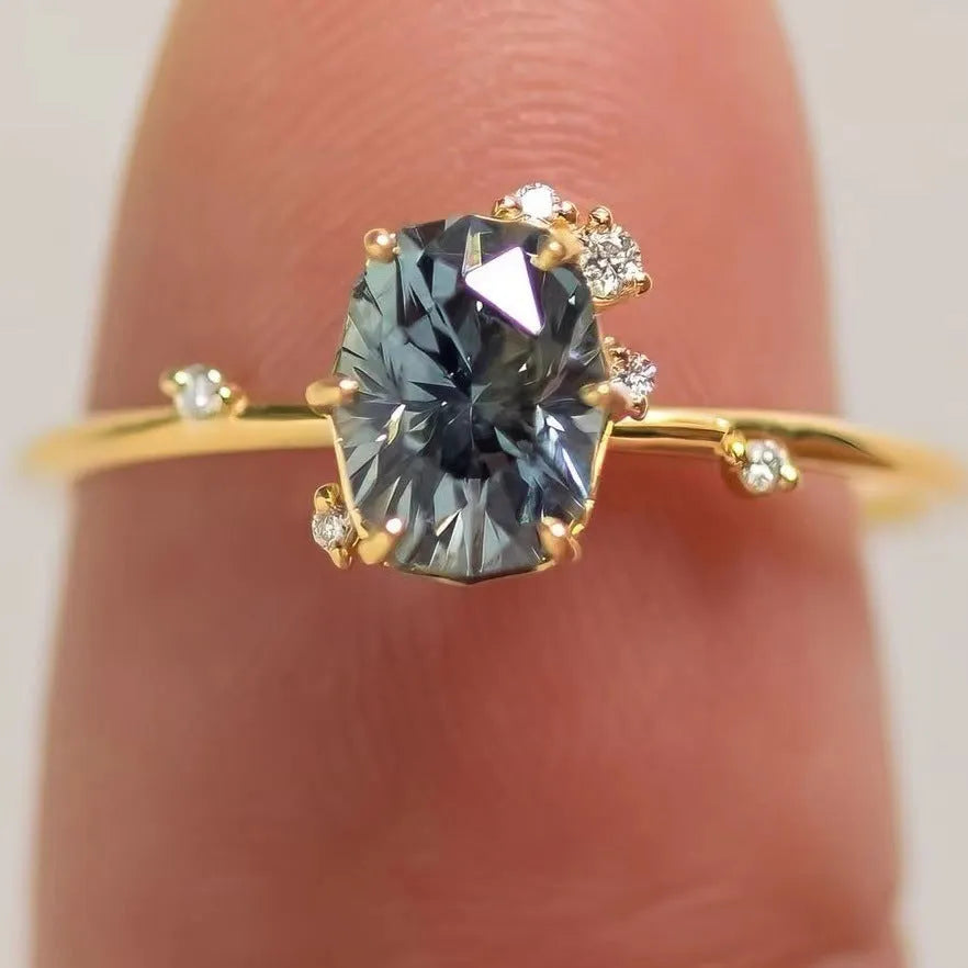 Gold plated women's ring with green zircon stone in floral design on a model's finger.