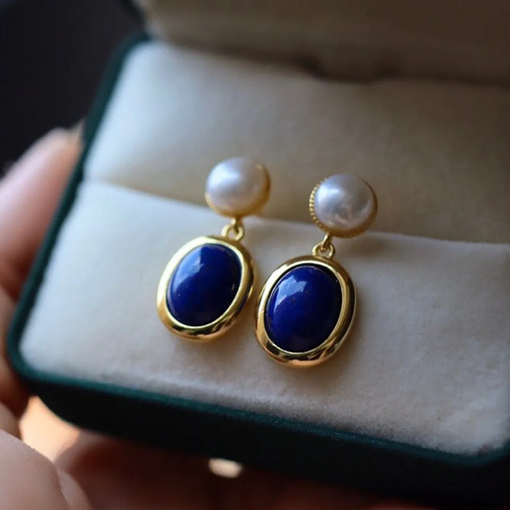 A pair of simple sterling silver drop earrings with a blue lapis lazuli pearl and auspicious patterns.