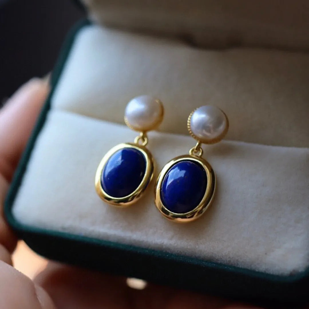 A pair of simple sterling silver drop earrings with a blue lapis lazuli pearl and auspicious patterns.