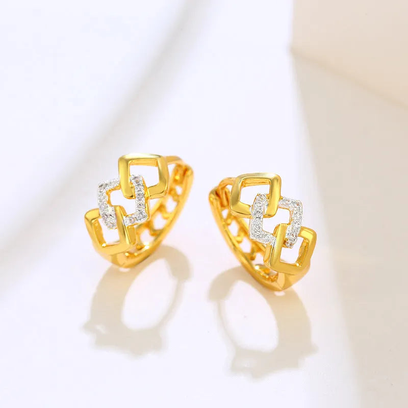 A pair of gold geometric earrings with a hollow out design and clip-on fastening.