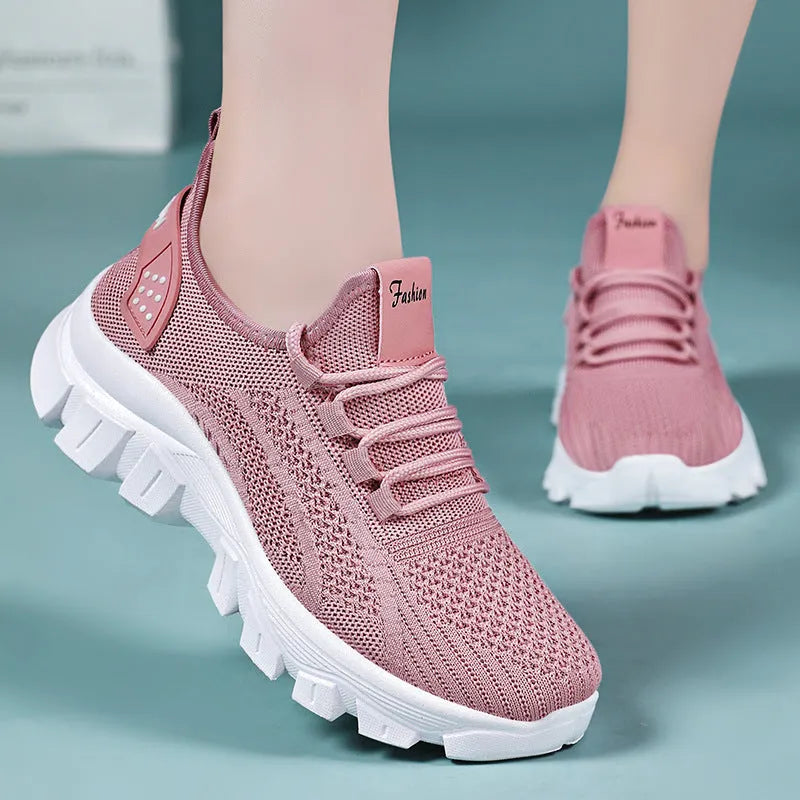 Women's white Flyknit running sneakers with round toe, flat heel, and thick PVC sole on a light background.