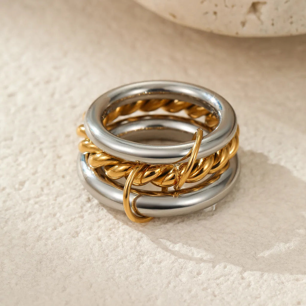 Stacked gold plated stainless steel rings showing layered jewellery look on female hand