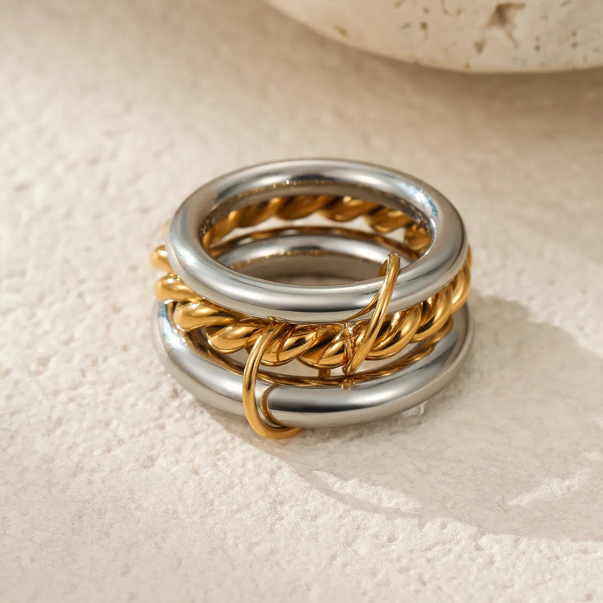 Stacked gold plated stainless steel rings showing layered jewellery look on female hand