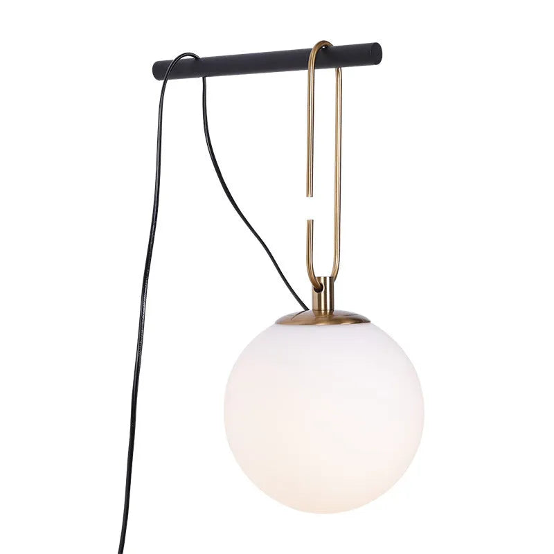 Contemporary clear glass wall light fixture with modern design on a white wall.