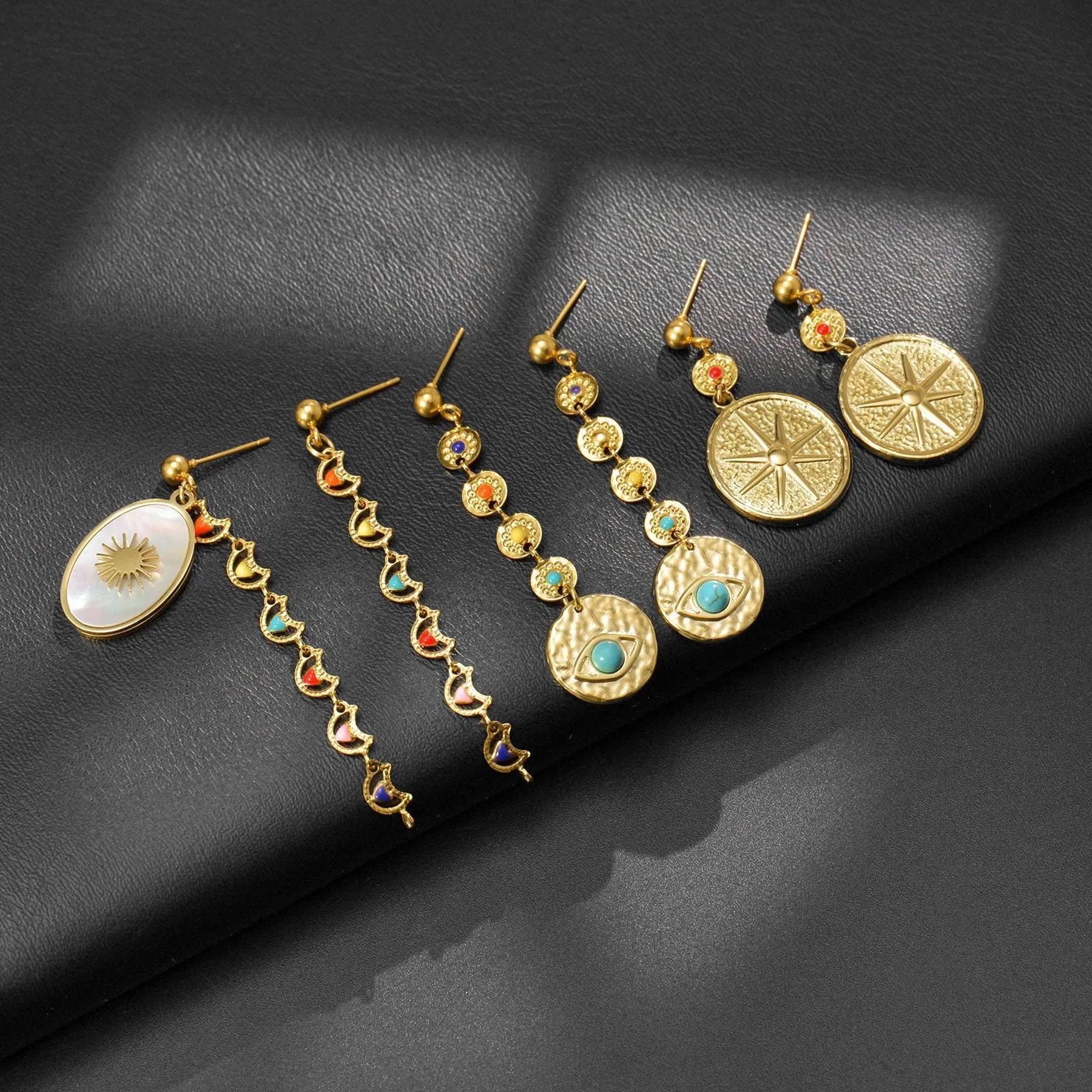 Geometric stainless steel earrings available in Eight Awn Star, Eye, and Shell Sun designs.