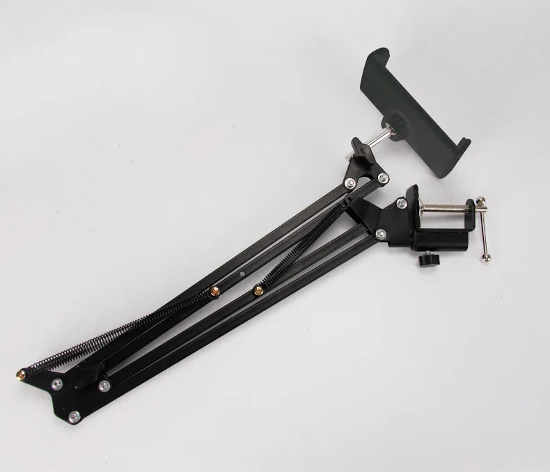 Black adjustable phone and tablet stand holding a mobile device on a desk.