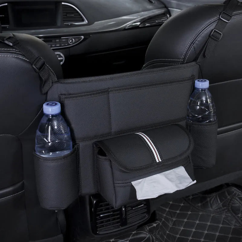 Black leather car interseat storage bag holding a tissue box, hanging between vehicle front seats.