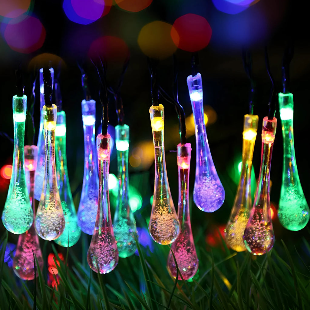 Solar-powered LED outdoor string lights with water drop-shaped pendants in garden setting