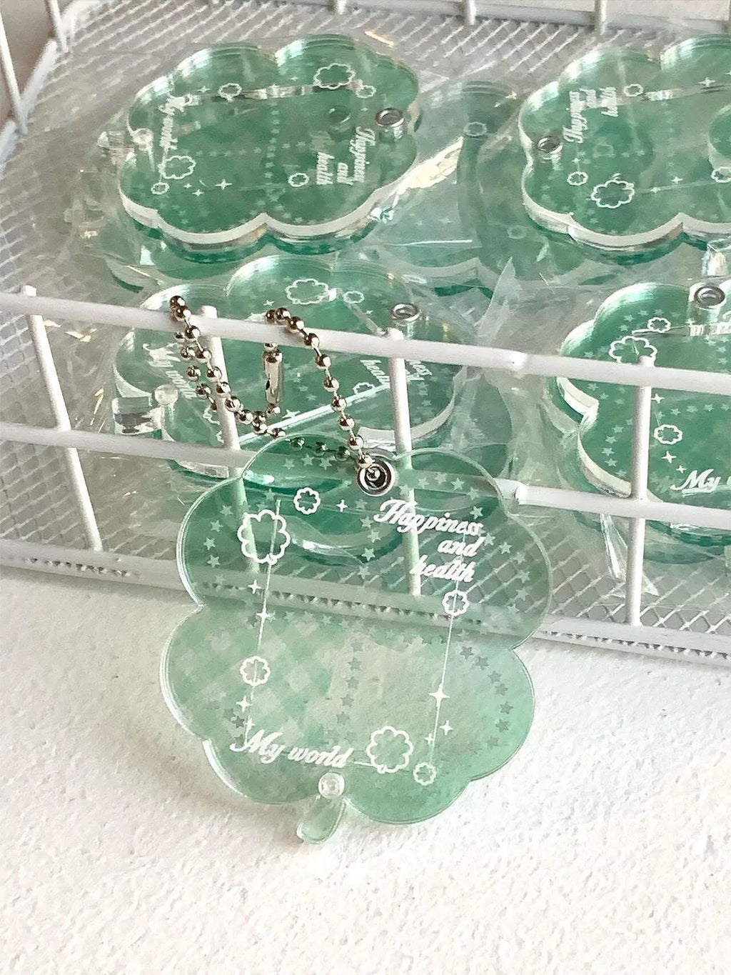 Acrylic four-leaf clover phone pendant keychain on a ring in blue, green, or mint.