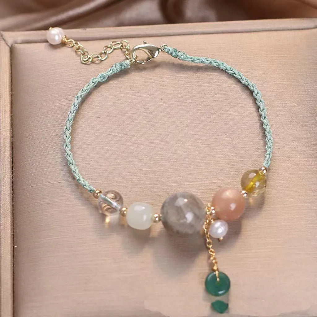 Women's hand-woven bracelet with peace buckle closure and crystal sequins in red, green, and blue colour options
