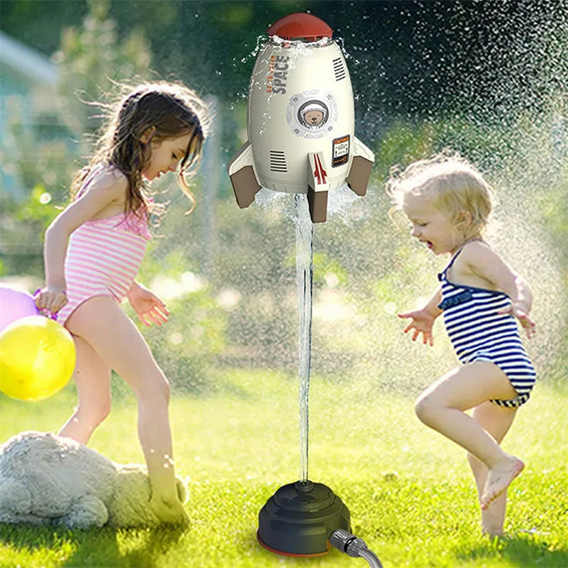 Water pressure rocket launcher toy on green grass with water spray, yellow rocket, and base connector