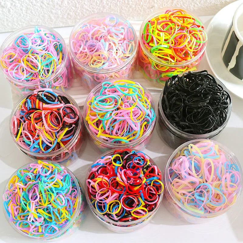 Open reusable container showing hundreds of thin, colourful TPU baby hair ties for toddlers.