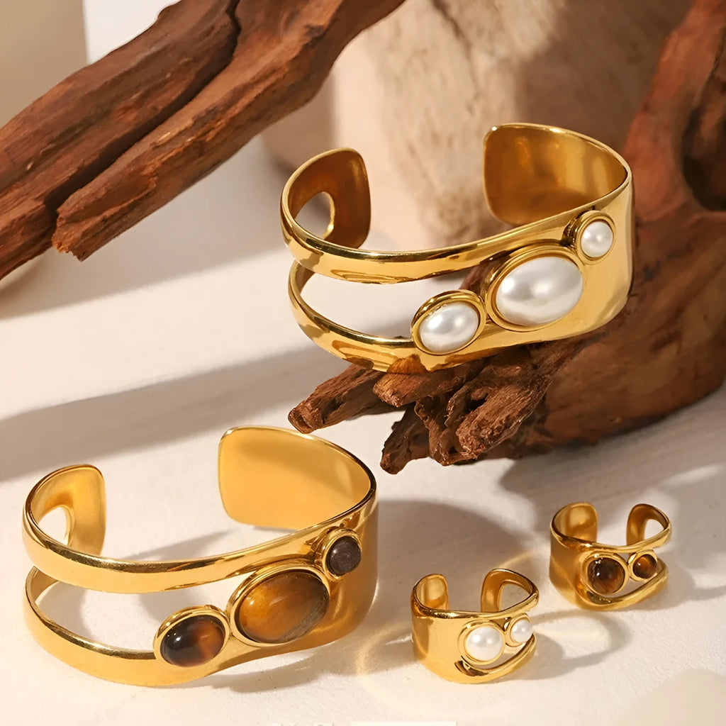 Stainless steel wide face bracelet inlaid with natural tiger eye stone on a neutral background