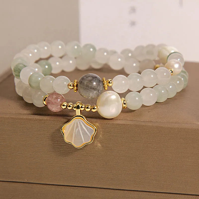 Women's artistic crystal bracelet with a green Tianshan Jade ginkgo leaf pendant and gold-plated accents.