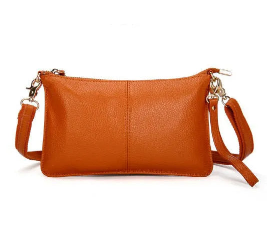 Structured cowhide lady slant bag in apricot colour with hand strap and shoulder strap, showing slim profile.