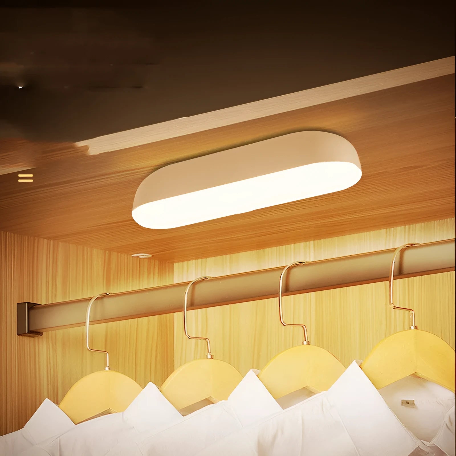 Fully automatic unplugged bedside night light for dormitory with magnetic base, USB rechargeable, showing yellow light mode on a dark bedside table