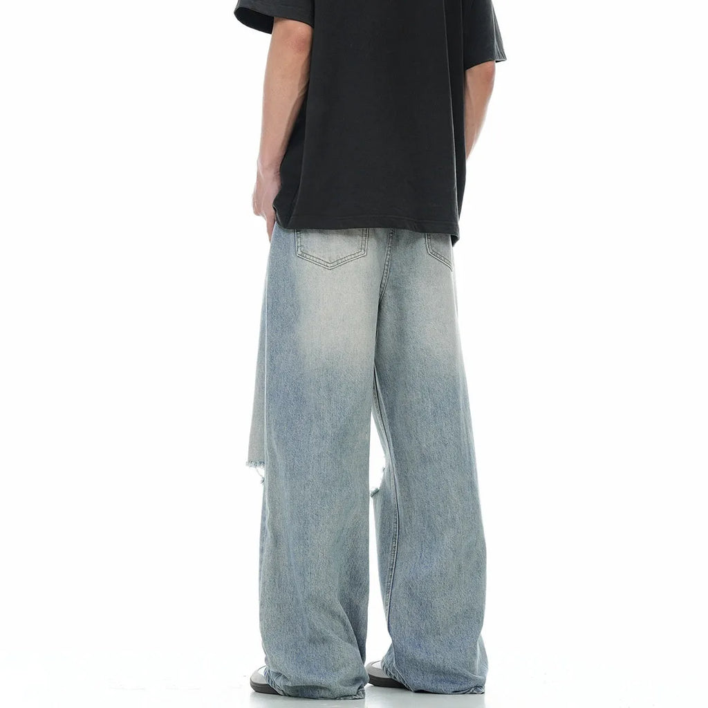 Denim blue straight-leg jeans with ripped details and zip fly closure